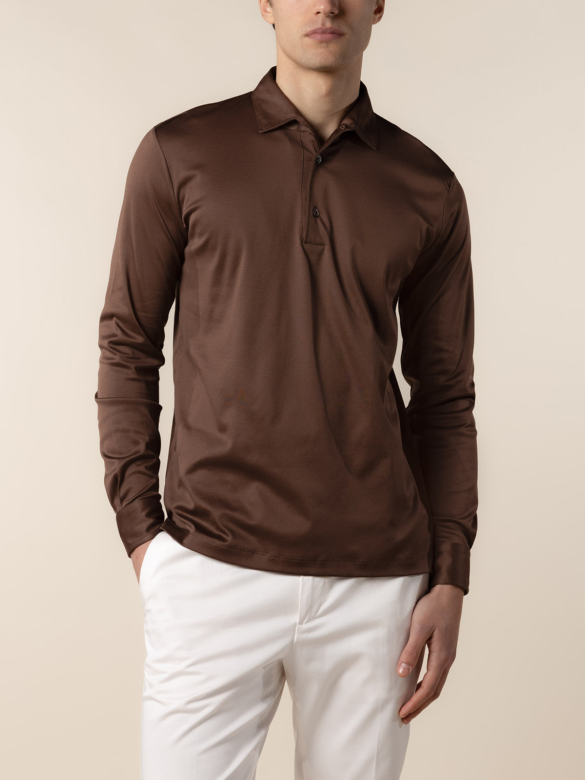 Aurélien longsleeve polo in chocolade bruin, gedragen met een witte broek
